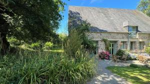 a stone house with a garden in front of it at Normandy Inn in Montbray