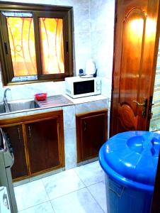 a kitchen with a sink and a microwave at Ouedraogo Property Management in Ouagadougou