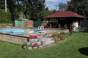a swimming pool in a yard with flowers in the grass at Apartmán Nelinka in Rudná pod Pradědem