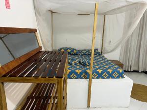 a bedroom with a bunk bed and a wooden bench at Meama Paje Guesthouse in Paje +5 photos
