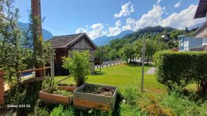 a garden with a small greenhouse and a shed at Sunhill Apartamente in Karrösten