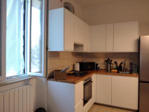 a kitchen with white cabinets and a refrigerator at Albizi Home in Pontassieve +6 photos