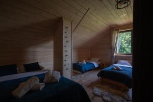 a room with two beds in a log cabin at Eno Chata 240 m2 na wyłączność dla grup in Chojnik