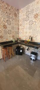 a room with a counter and a wall with a table at Quarto Privativo in Caparaó Velho