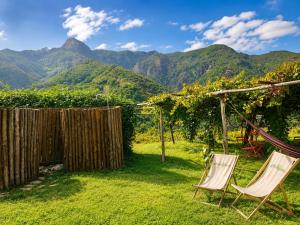 a pair of chairs in a yard with mountains in the background at Ecoglamping Tramonti in Tramonti