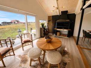 a living room with a table and chairs and a fireplace at Domos by Toore Patagonia in Puerto Natales