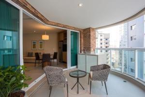 an apartment with a balcony with chairs and a table at 2 quartos- Unique Ex-Estanconfor veja o mar do ap 1408 in Santos