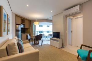 a living room with a couch and a television at 2 quartos- Unique Ex-Estanconfor veja o mar do ap 1408 in Santos
