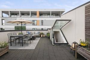 an outdoor patio with a table and an umbrella at Elite Townhouse @ the Shipyards in North Vancouver