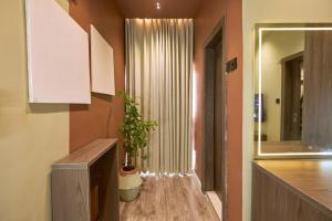 a room with a hallway with a mirror and a plant at The Chevron House in Ikuata