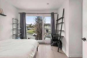 a bedroom with a bed and a desk and a window at Elite Townhouse @ the Shipyards in North Vancouver