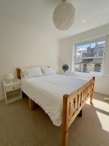 a bedroom with a large bed and a window at Buttercup Victorian House for 6 in St. Leonards