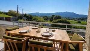 a wooden table and chairs on a balcony with a view at Villa Madalena in Coucieiro