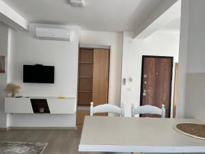 a living room with a table and chairs and a tv at Rayand in Mostar