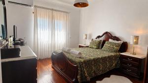 a bedroom with a bed and a dresser and a window at Villa Madalena in Coucieiro