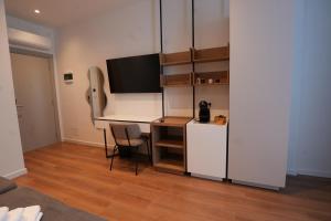 a small office with a desk and a refrigerator at Eden Center Rooms in Durrës