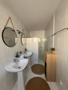 a white bathroom with a sink and a shower at L'Échappée Cévenole in Gagnières