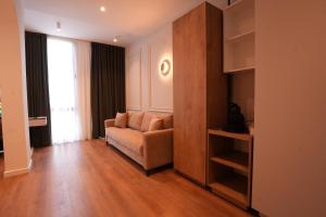 a living room with a couch and a large window at Eden Center Rooms in Durrës