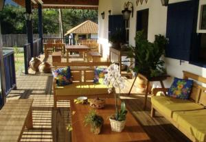 a patio with couches and potted plants at Pousada do Café - Chalé 1 -São Sebastião da Grama in São Sebastião da Grama