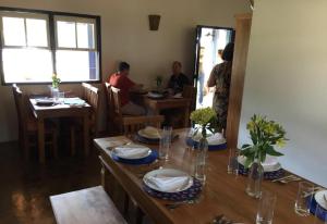a group of people sitting at tables in a restaurant at Pousada do Café - Chalé 1 -São Sebastião da Grama in São Sebastião da Grama