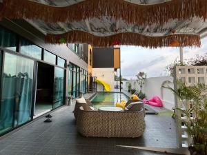 a living room with a couch and a swimming pool at ซันไบร์ท พลูวิลล่า 2 in Ban Huai Yai