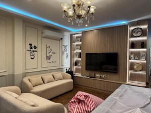 a living room with a couch and a television at ซันไบร์ท พลูวิลล่า 2 in Ban Huai Yai