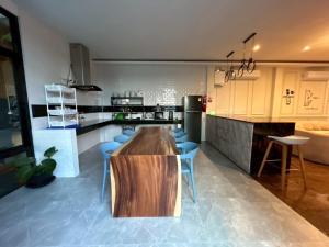 a kitchen with a wooden table and blue chairs at ซันไบร์ท พลูวิลล่า 2 in Ban Huai Yai