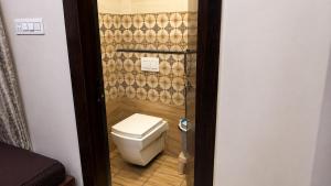 a small bathroom with a toilet in a room at Shree Vaishnav Yatri Grah Near Mahakaleshwar Temple in Ujjain