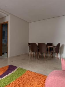 a room with a table and chairs and a colorful rug at Chez Iceyy in Tangier