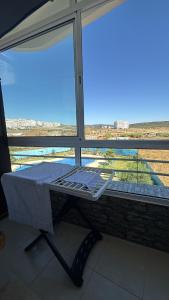 a bed in front of a window with a view at Chez Iceyy in Tangier