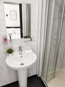 a bathroom with a white sink and a shower at Alexandra Hotel Blackpool in Blackpool