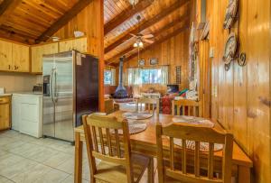 a kitchen and dining room with a table and a refrigerator at Bear's Den in Idyllwild
