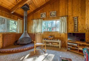 a living room with a fireplace and a tv at Bear's Den in Idyllwild