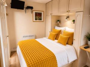 a bedroom with a large bed with yellow pillows at Harman Suites 1 & 2 in Leeds