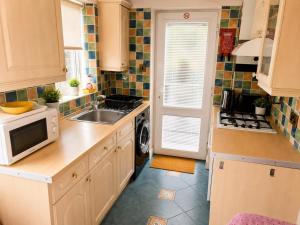 a kitchen with a sink and a microwave at Harman Suites 1 & 2 in Leeds