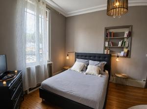 a bedroom with a bed and a tv and a window at Gîte du Pré Nattier - Gisors centre in Gisors