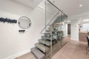 a glass staircase in a room with a mirror at Elite Townhouse at the Shipyaards in North Vancouver
