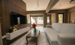 a living room with a couch and a tv at Guney House by Villa Safiya in Fethiye