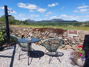 a table and two chairs on a gravel patio at Knocknafallia in Cappoquin