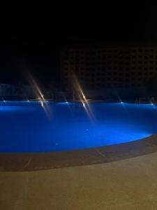 a swimming pool at night with a building in the background at Chez Iceyy in Tangier