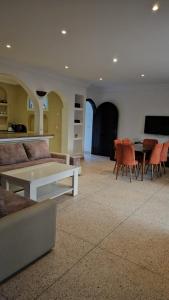 a living room with a couch and a table and chairs at L'Echappée Belle in Sidi Boû el Fedâïl
