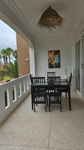 a dining room with a table and chairs on a balcony at L'Echappée Belle in Sidi Boû el Fedâïl