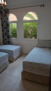 two beds in a room with two windows at L'Echappée Belle in Sidi Boû el Fedâïl +18 photos