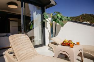 a table and chairs on a balcony with a bowl of fruit at Guney House by Villa Safiya in Fethiye