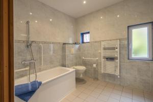a bathroom with a bath tub and a toilet at L'instant Beaun'heur in Merceuil +38 photos