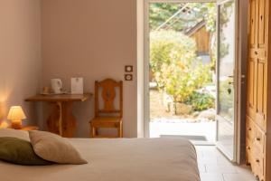 a bedroom with a bed and a sliding glass door at L'instant Beaun'heur in Merceuil