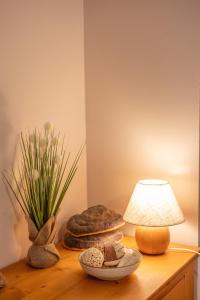 a table with a lamp and a vase of flowers at L'instant Beaun'heur in Merceuil