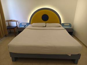 a bed with a yellow face headboard in a room at The Moon Hotel Panvel in Āpta +5 photos