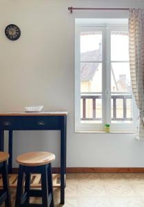 a room with a fireplace and a window with stools at Studio Catherine in Sainte-Céronne-lès-Mortagne +3 photos