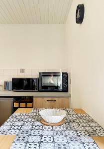 a kitchen with a microwave and a bowl on a counter at Studio Catherine in Sainte-Céronne-lès-Mortagne